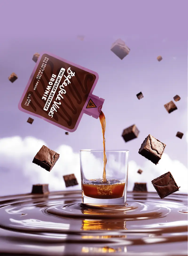 BakeSale Vibes brownie beverage pouch pouring into glass with floating brownies against dreamy purple sky